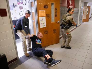Henderson County Sheriff’s Deputy Cody Baker (left) drags a victim portrayed by Athens...