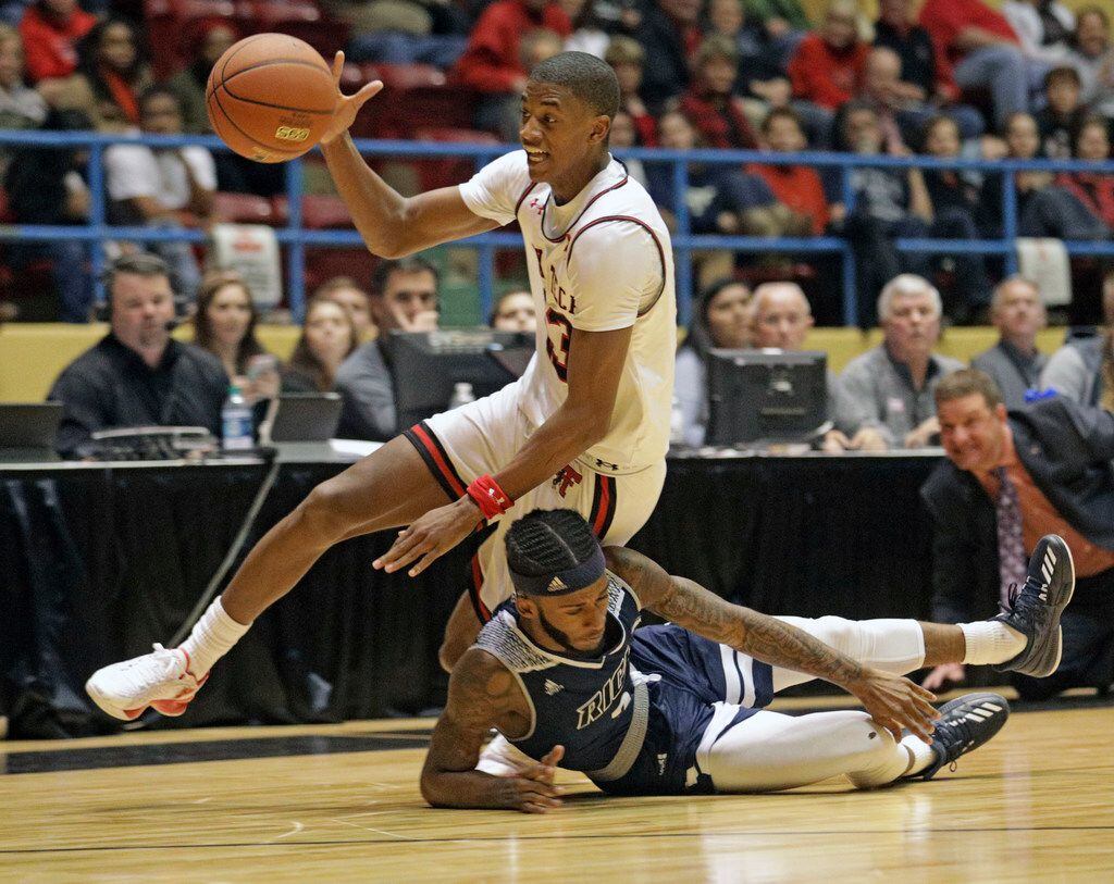 Texas Tech's Jarrett Culver (23) falls down on Rice's Ako Adams (3) during the second half of an NCAA college basketball game Saturday, Dec. 16, 2017, in Lubbock, Texas. (AP Photo/Brad Tollefson)