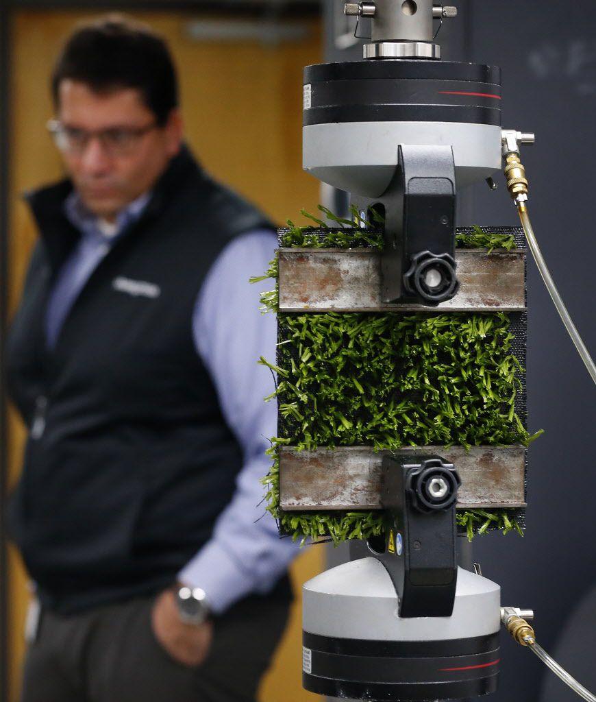 Shaw Sports Turf director of research and innovation Philipe Aldahir watches as a piece of...