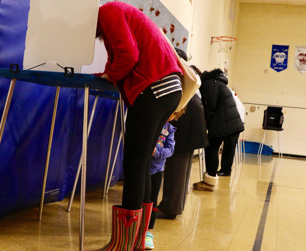 Courtney Brown, left, of Richardson votes with her daughter Claire Brown, 3, at Yale...