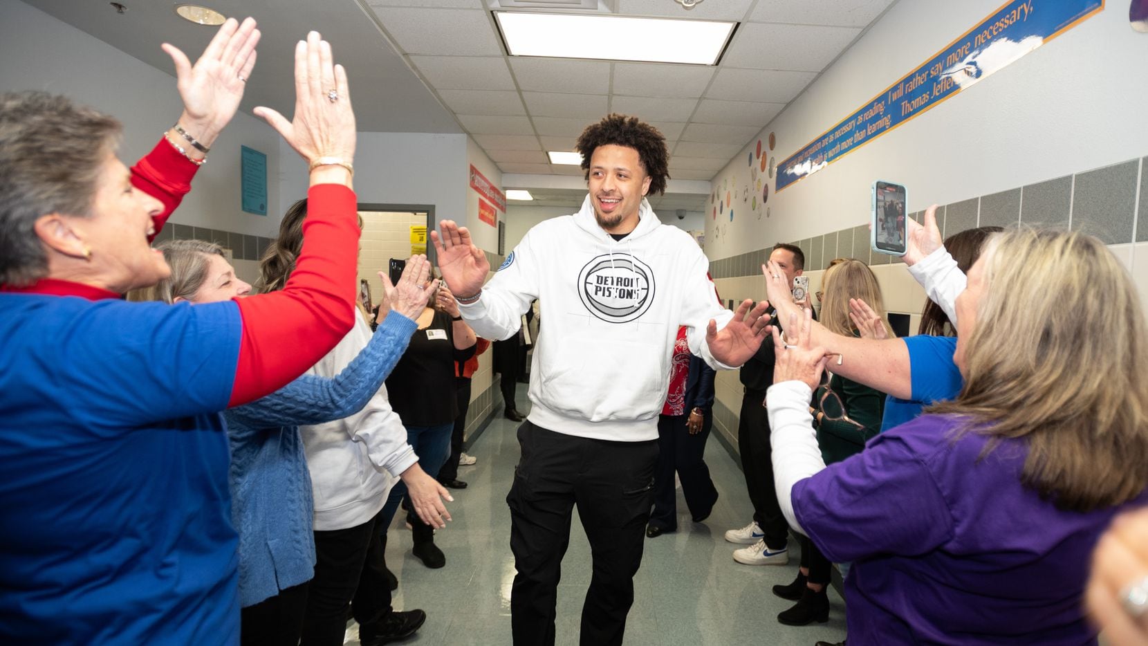 Detroit Pistons guard Cade Cunningham, center, is welcomed back to his elementary alma mater...