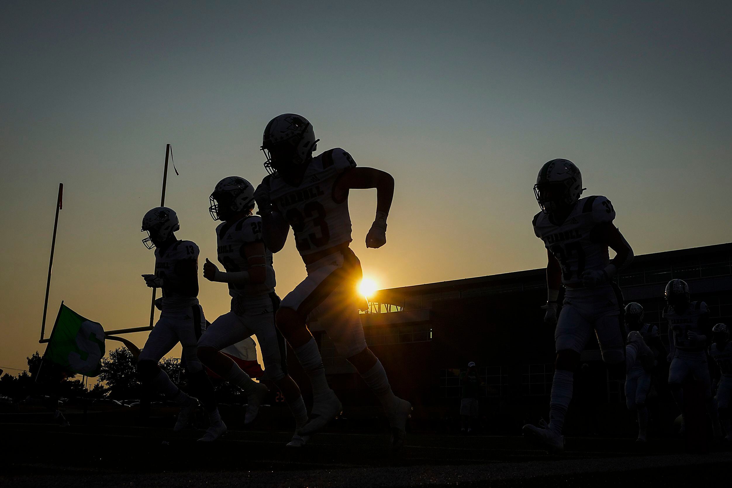 Southlake Carroll players take the field before a high school football game against against...