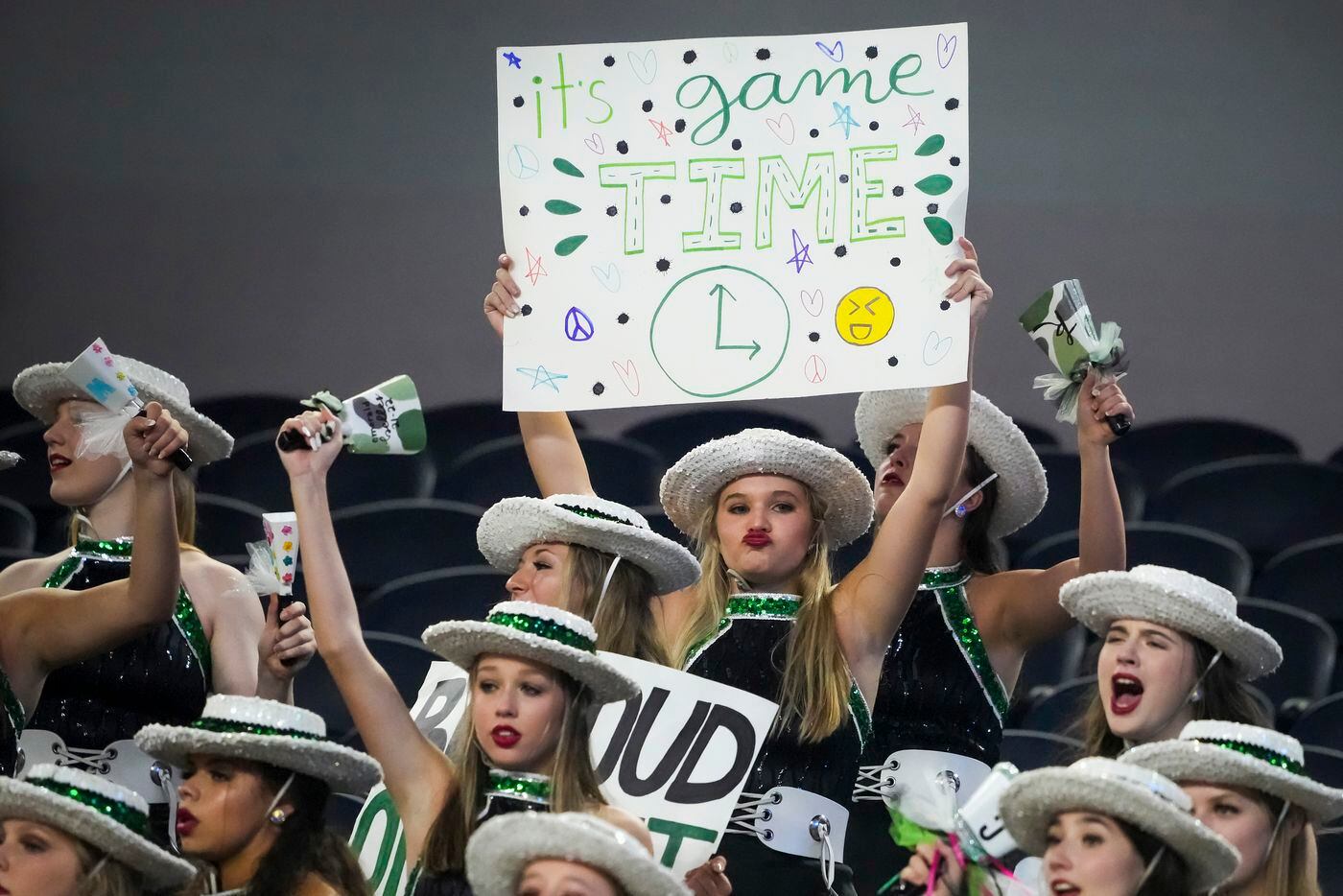 Members of the Southlake Carroll Emerald Belles Drill Team cheer their team during the...