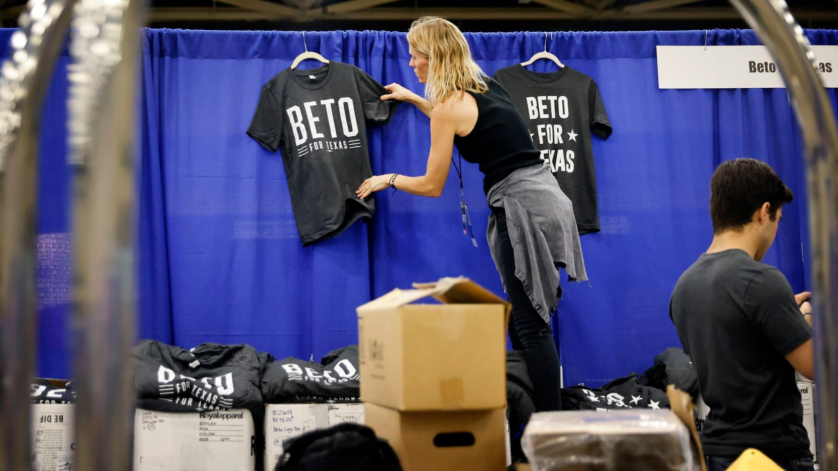 Staffer Chrissy Kleberg hangs up Beto For Texas t-shirts at his booth as the team set up on...