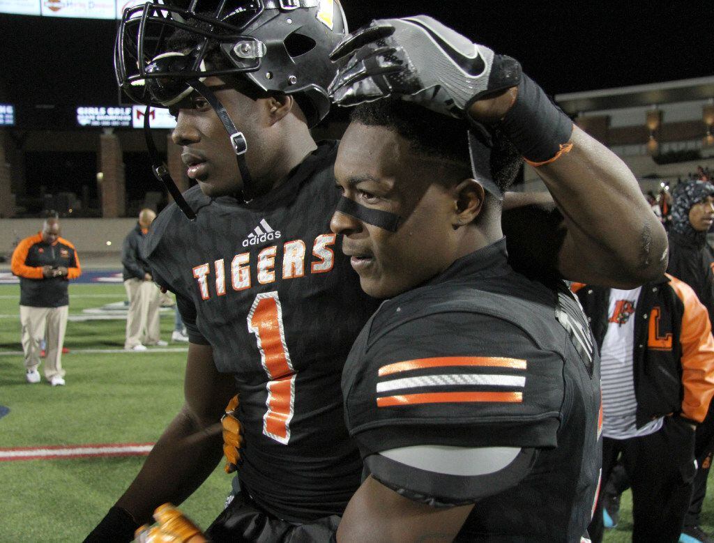Lancaster Tigers receivers Omar Manning (1) and Cartrell Thomas (2) share a hug following...