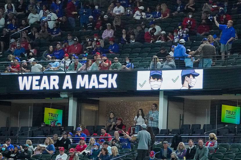 Signs encouraged fans to wear face masks as the Texas Rangers faced the Baltimore Orioles at...