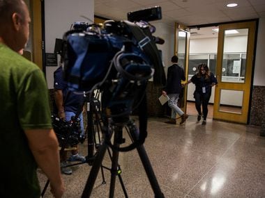 Reporters walk in the hallway outside the central jury room where would-be jurors answered...