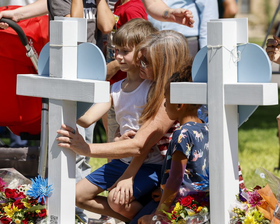 Angela Turner, 49, comforts her nephew Bruce Mathis, 8, at a cross for his sister Miranda...