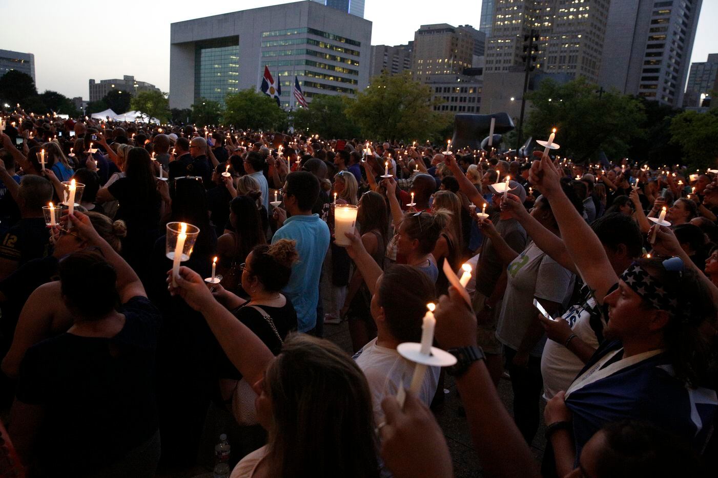Participants hold candles during a candlelight vigil hosted by the Dallas Police Association...