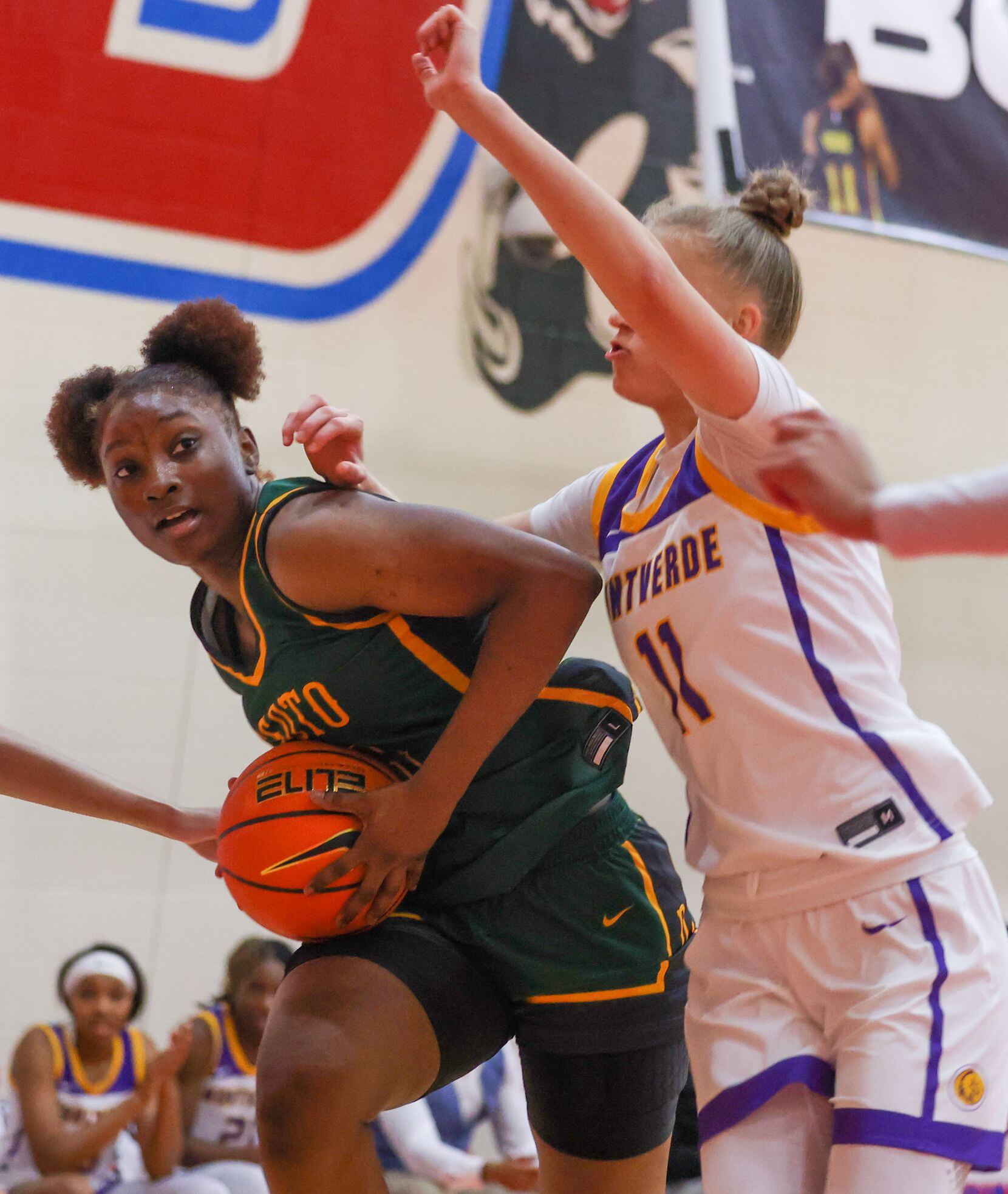 DeSoto shooting guard MaRiya Vincent (21) moves closer to the net with pressure from...