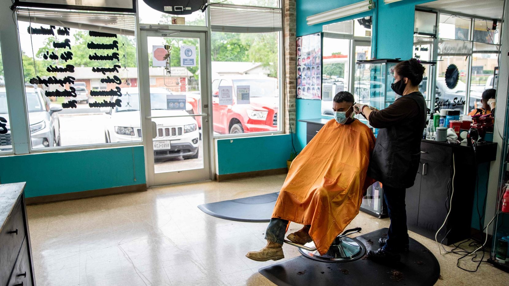 A young man gets his hair cut at a barbershop amid the coronavirus pandemic in Austin, Texas...