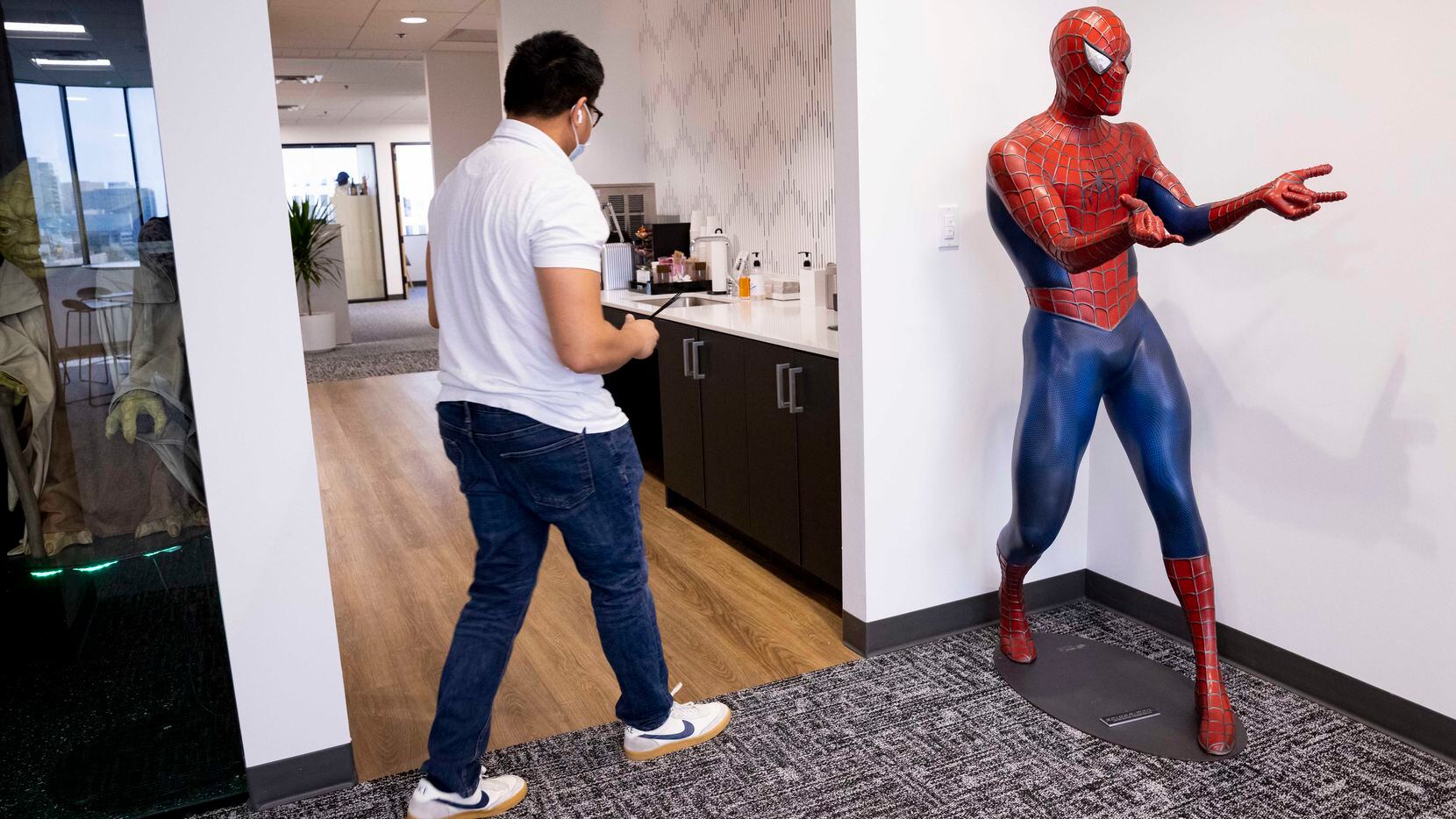 Arya Raval walks by a Spiderman statue on Sept. 2 at the Camelot office in Dallas.