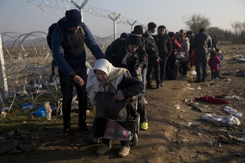 Una anciana siria recibe ayuda de su hijo para cruzar de Grecia a Macedonia. Grecia es el...