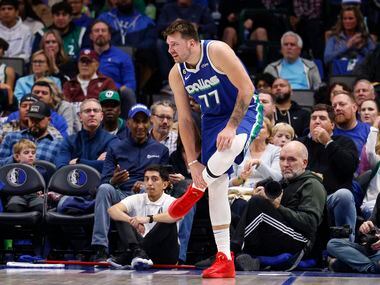 Dallas Mavericks guard Luka Doncic (77) grabs at his lower leg after being fouled during the...