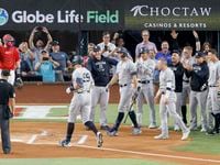 Members of the New York Yankees greet New York right fielder Aaron Judge (99) at home plate...