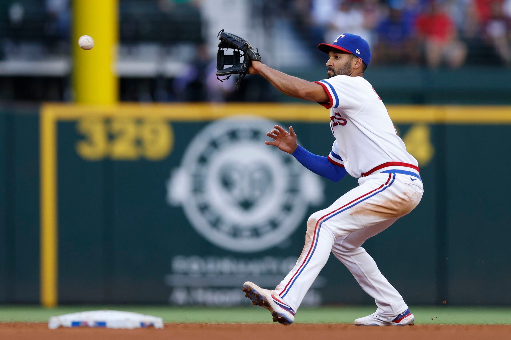 Texas Rangers second baseman Marcus Semien (2) fields a ball before throwing to first for an...