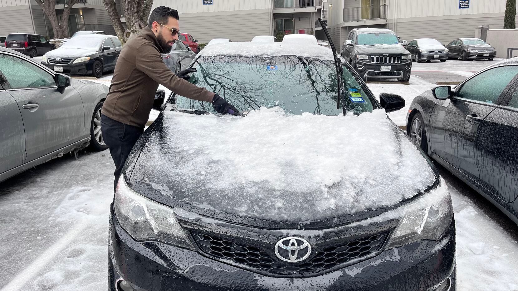 Víctor Jasso quita el hielo de su auto para poder conducir a su turno como gerente en FedEx...
