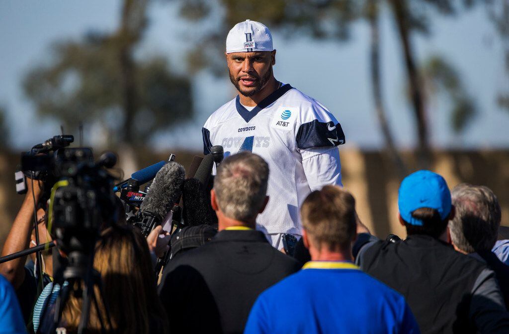 Dallas Cowboys quarterback Dak Prescott (4) answers questions from reporters while standing...