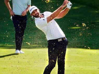 Pices of turf fly in the air as PGA Tour golfer Dustin Johnson makes his approach shot from...