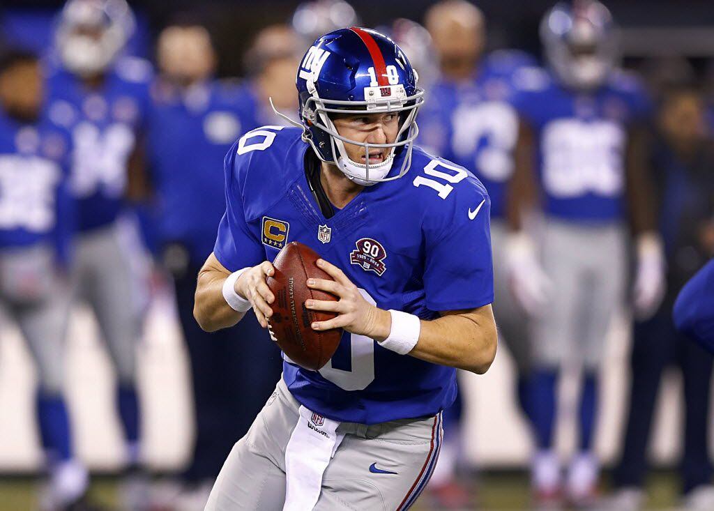 New York Giants quarterback Eli Manning (10) rolls out looking for a receiver against the...