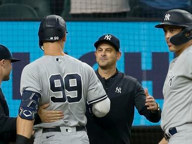 New York Yankees manager Aaron Boone (center right) congratulates right fielder Aaron Judge...