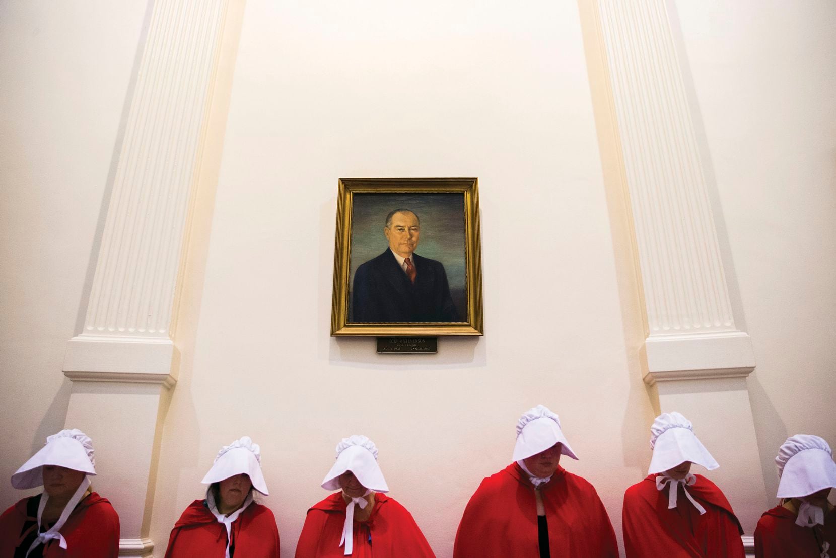Dressed as the oppressed characters of "The Handmaid's Tale," supporters of women's health rights stand under a portrait of former Gov. Coke Stevenson inside the Capitol rotunda in Austin as the Texas Senate considered several abortion-related bills in a legislative special session.