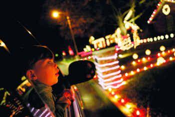 Un niño observa desde un carro las decoraciones de casas en el barrio Interlochen de Arlington.