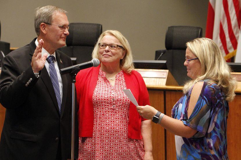 Rick Stopfer, junto a su esposa Melanie (centro) toma juramento como nuevo alcalde de...