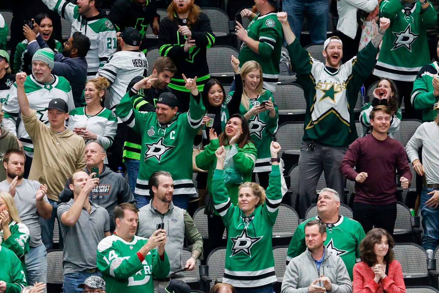Dallas Stars fans celebrate a goal by center Tyler Seguin (91) during overtime of an NHL...