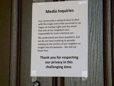 A sign posted on a neighbor's door next to the house where suspected Las Vegas gunman...