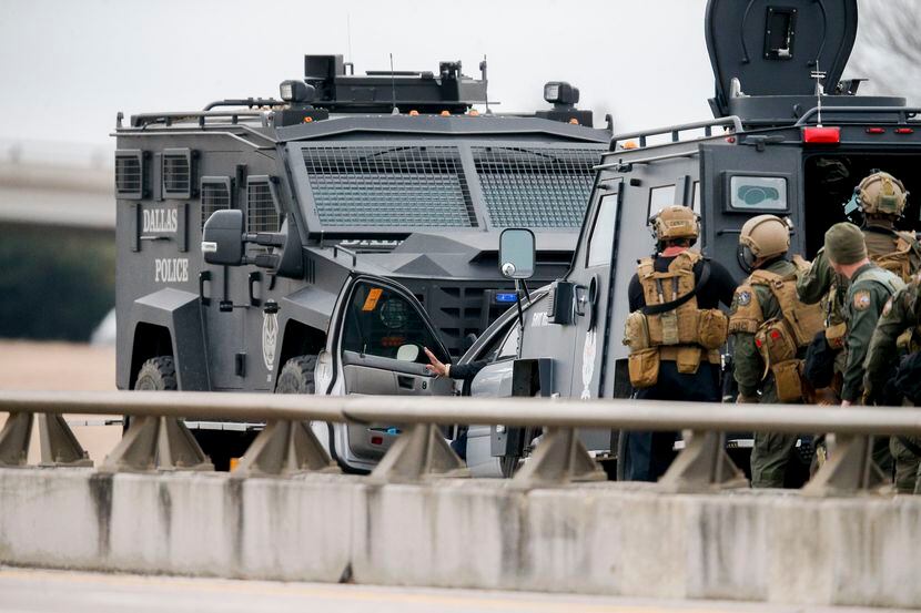 SWAT officers prepare to take a suspect into custody during a standoff on I-20 at I-35E,...