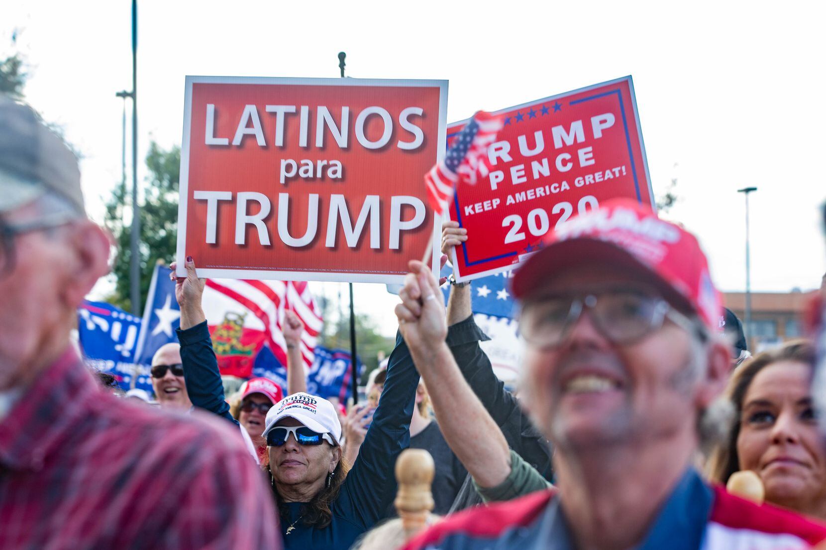 Una simpatizante del presidente Donald Trump sostiene un cartel que dice "Latinos para...