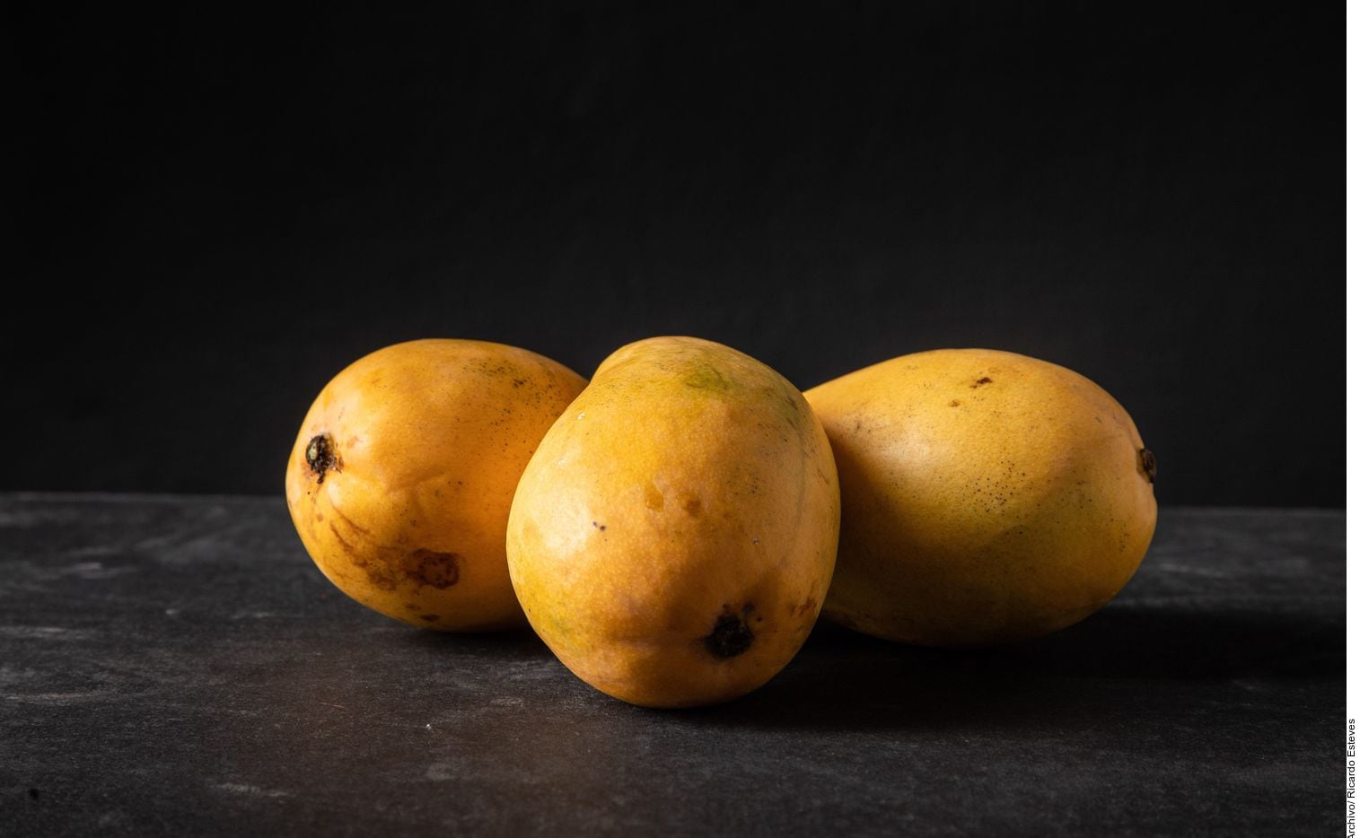 Foto de tres mangos amarillos.