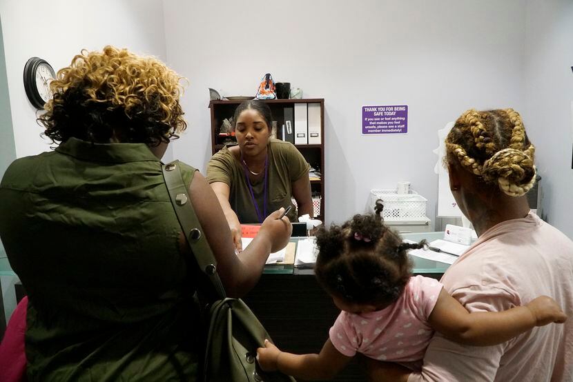 Resident Advocate Kari Webb (center) assists clients at the women's shelter at Family Place...