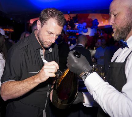 Max Scherzer signs a Champagne bottle at Al Biernat's steakhouse on Oak Lawn Avenue in...