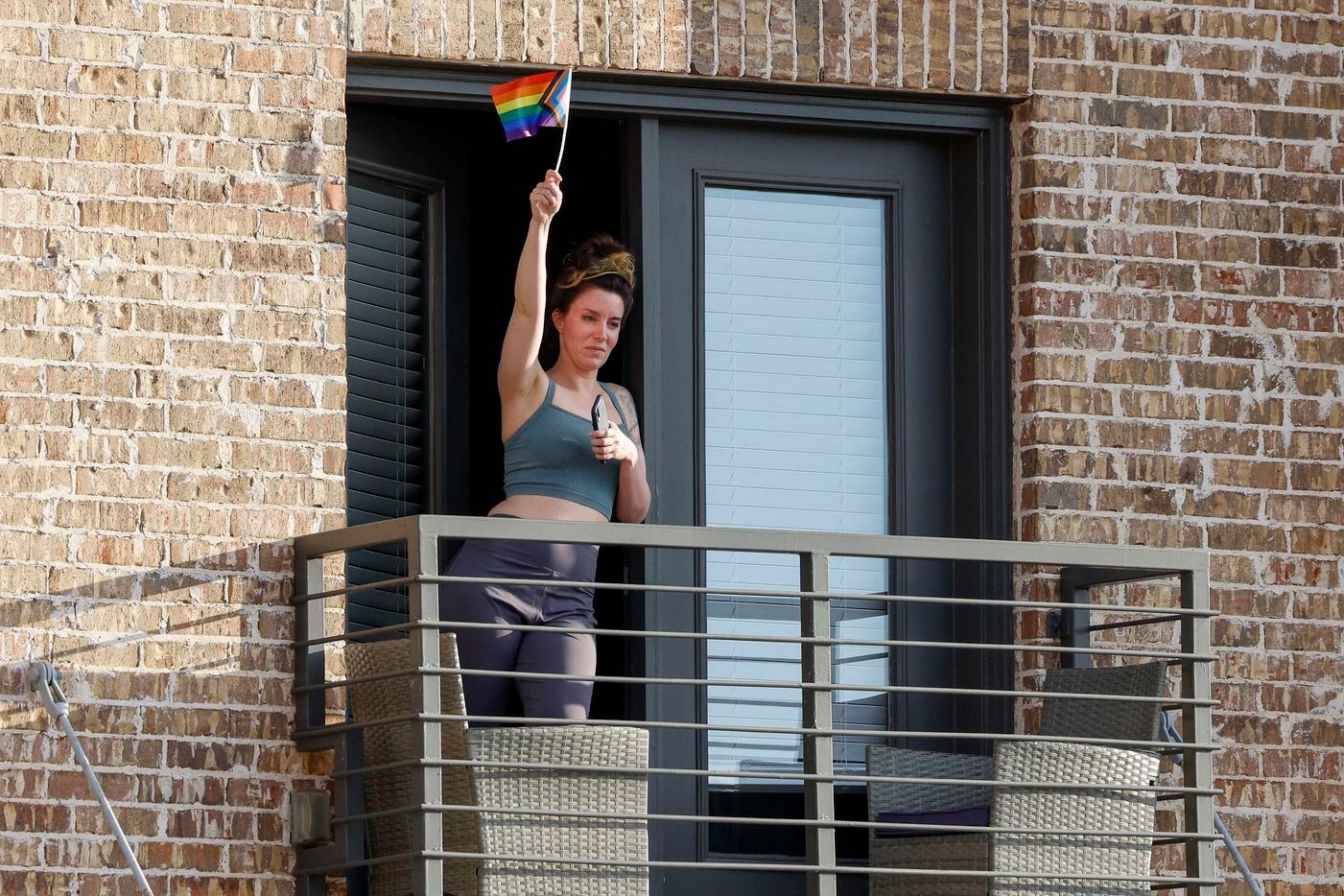 A woman waves a pride flag as supporters of abortion rights march in the streets near the...