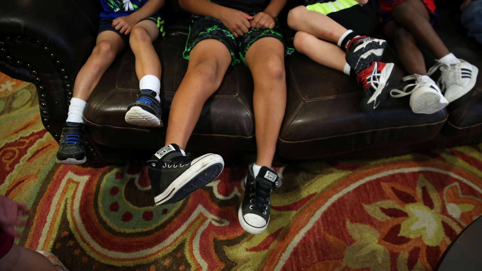 Boys sit on the couch at Jonathan's Place, which serves abused and neglected children, in Garland on June 30, 2017. 