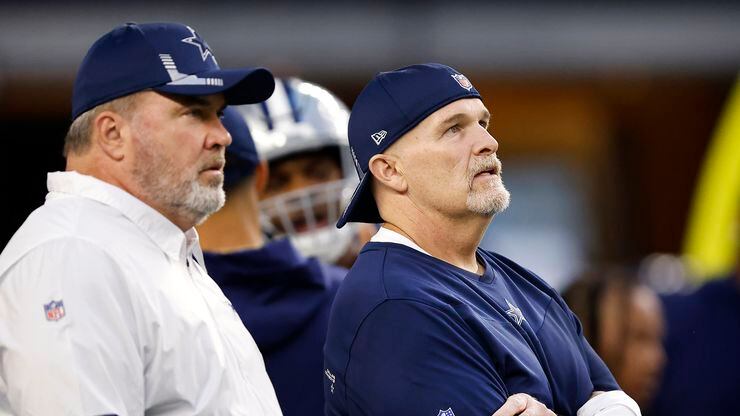 Dallas Cowboys head coach Mike McCarthy (left) and defensive coordinator Dan Quinn watch their players during pregame warmups at AT&T Stadium in Arlington, Monday, September 27, 2021.