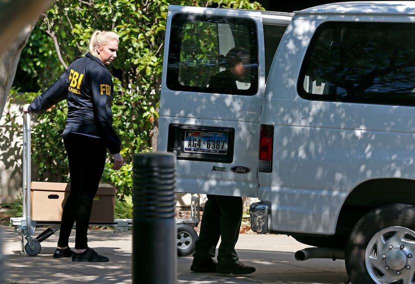 FBI agents load boxes into a van while the federal agents raid the Medoc Health Services...