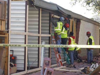 Crews work as they board up damaged openings at Extra Space Storage in Grapevine on...