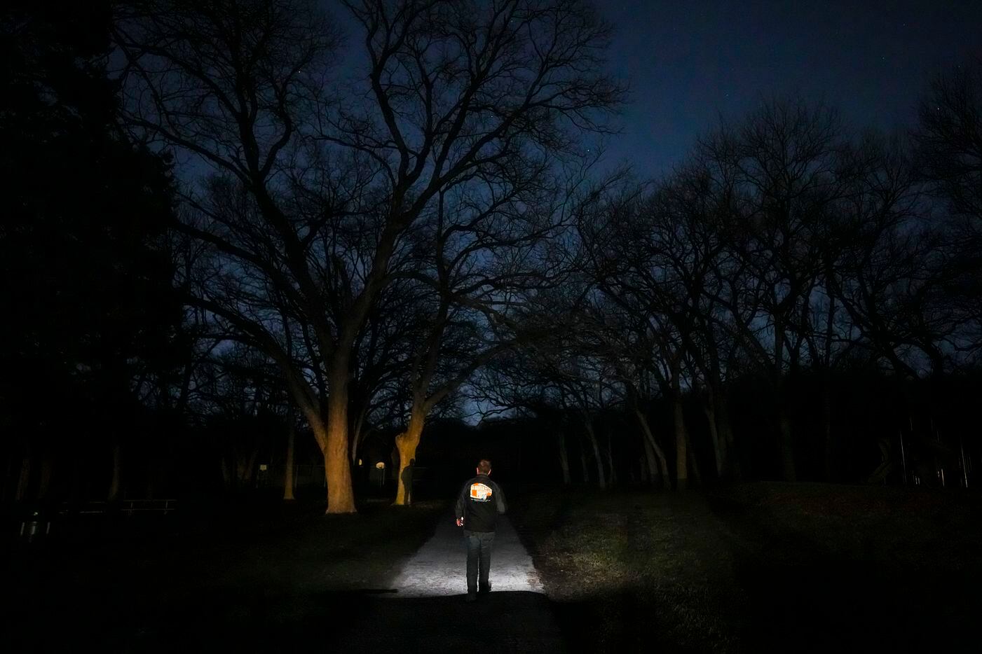 Charlie Leavitt, director of Metro Relief, walks through darkened Wonderview Park looking...