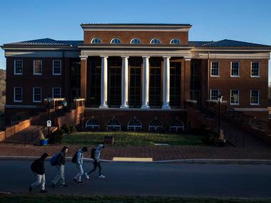 Students walk past Kenan Hall as sun descends at Woodberry Forest School in Orange, Va. 