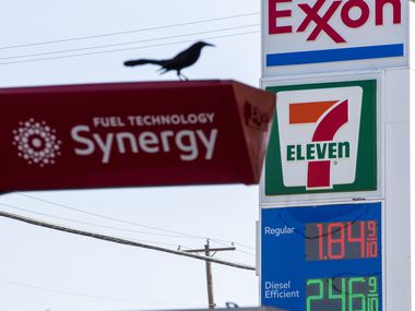 Signs advertise low gas prices at an Exxon gas station in Dallas on Thursday, March 12, 2020.