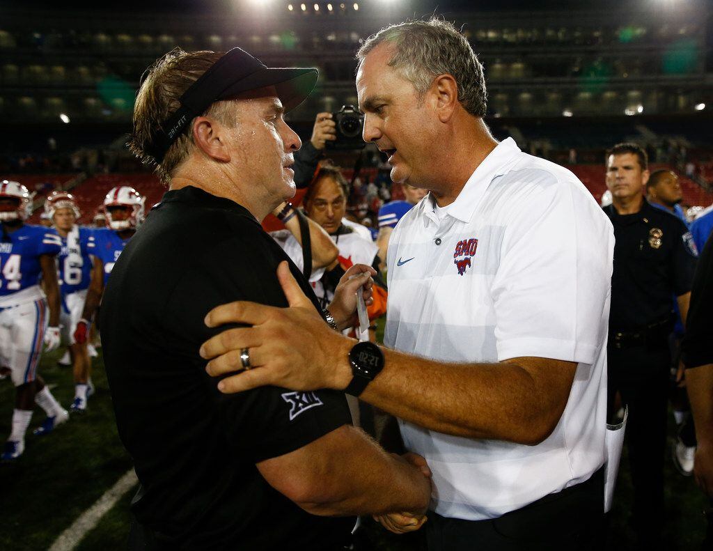 SMU head coach Sonny Dykes, right, and TCU head coach Gary Patterson, left, shake hands...