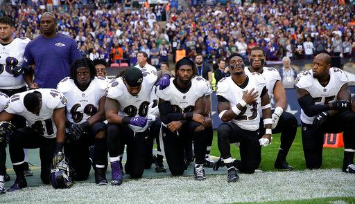 ugadores de los Ravens de Baltimore se hincan durante la interpretación del himno nacional...