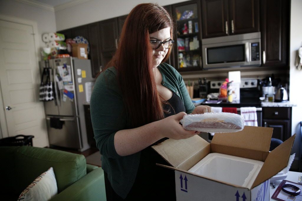 Hannah Wise opens up a delivery containing her medicine at her home in Dallas on April 27,...