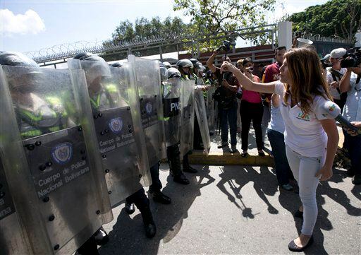 Una estudiante universitaria se enfrenta a la policía durante una protesta exigiendo un...