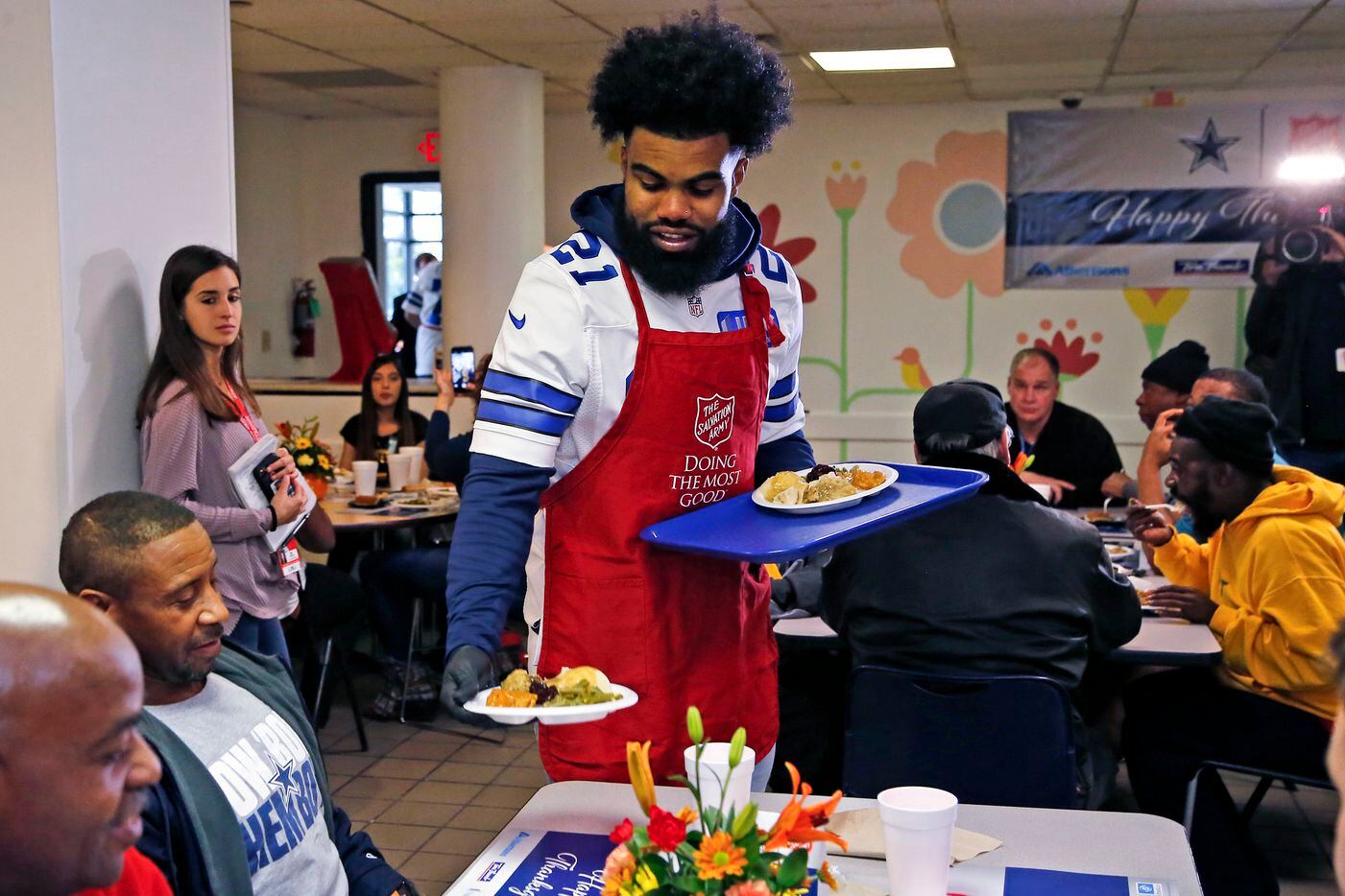 Dallas Cowboys running back Ezekiel Elliott serves a lunch meal to Anthony Butler, 44, as...