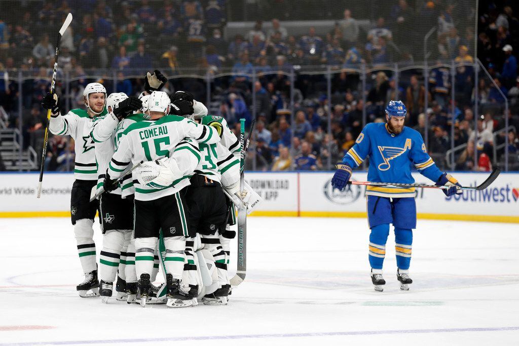 Members of the Dallas Stars celebrate as St. Louis Blues' Ryan O'Reilly, right, skates past...