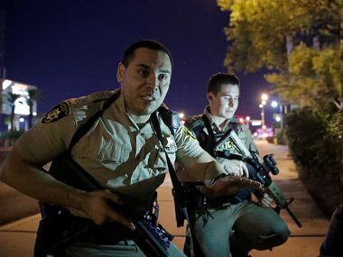 Police advise people to take cover at the scene of a shooting near the Mandalay Bay resort...